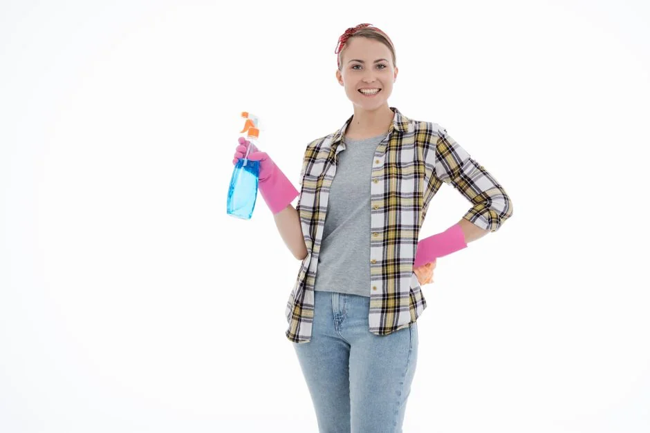 Une femme enveloppe avec soin un canapé dans un matériau de protection tout en préparant des cartons dans une pièce lumineuse.